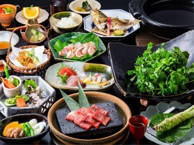 A full dinner spread at Shirakabe: sashimi, beef on hot stone, wasabi and greens for the pot