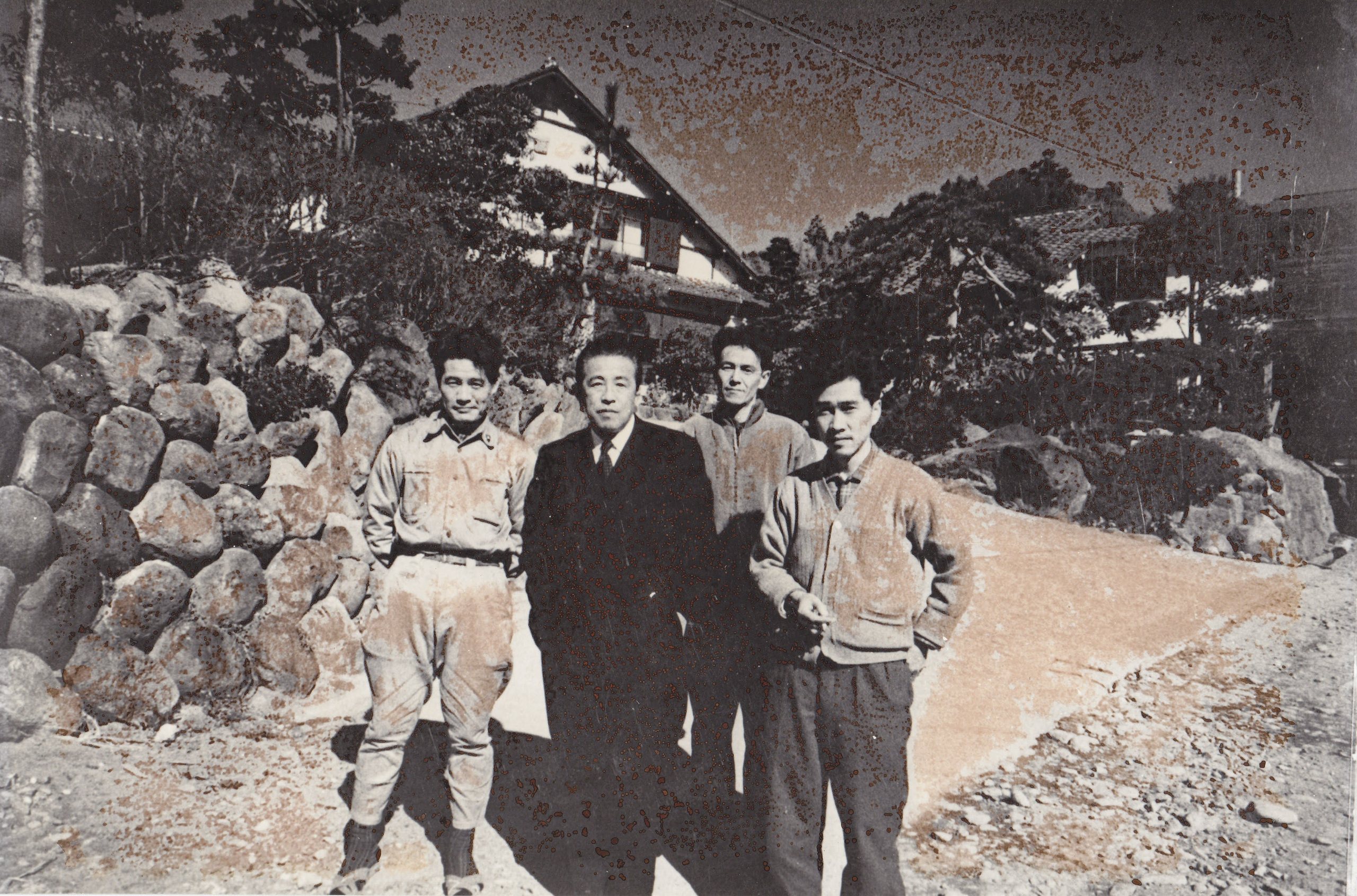 Four men photographed in front of Shirakabe in its founding years